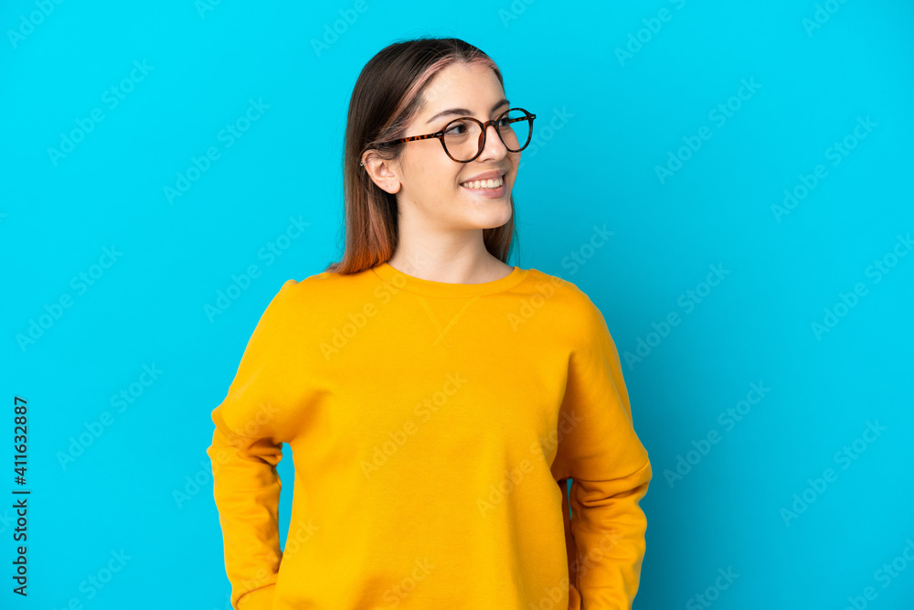 Young caucasian woman isolated on blue background thinking an idea while looking up