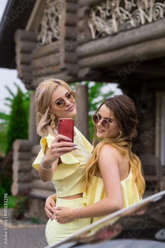 Portrait of two pretty young bridesmaids in yellow dresses