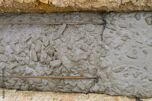 Freshly poured reinforced concrete in a trench. Construction of a monolithic strip foundation of a building. photo