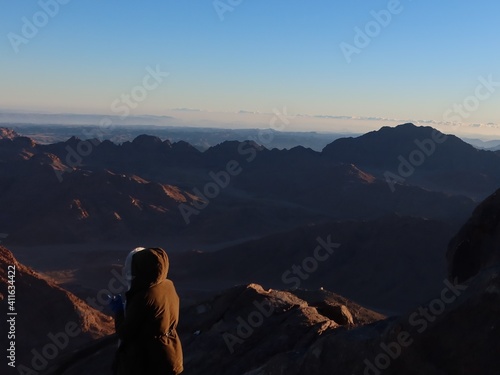 A woman watching the sunrise on the top of mountain Moses in Saint Catherine in Sinai in Egypt