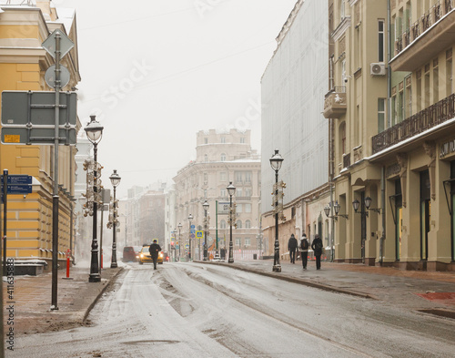 Moscow, Russia. Jan 22, 2021:  Bolshaya Nikitskaya street. Old houses, lanterns, people walking photo