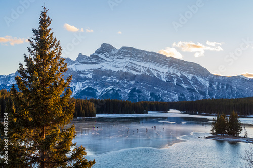 Beautiful view of people ice-skating on the Two Jack Lake in Banff national park, Canada