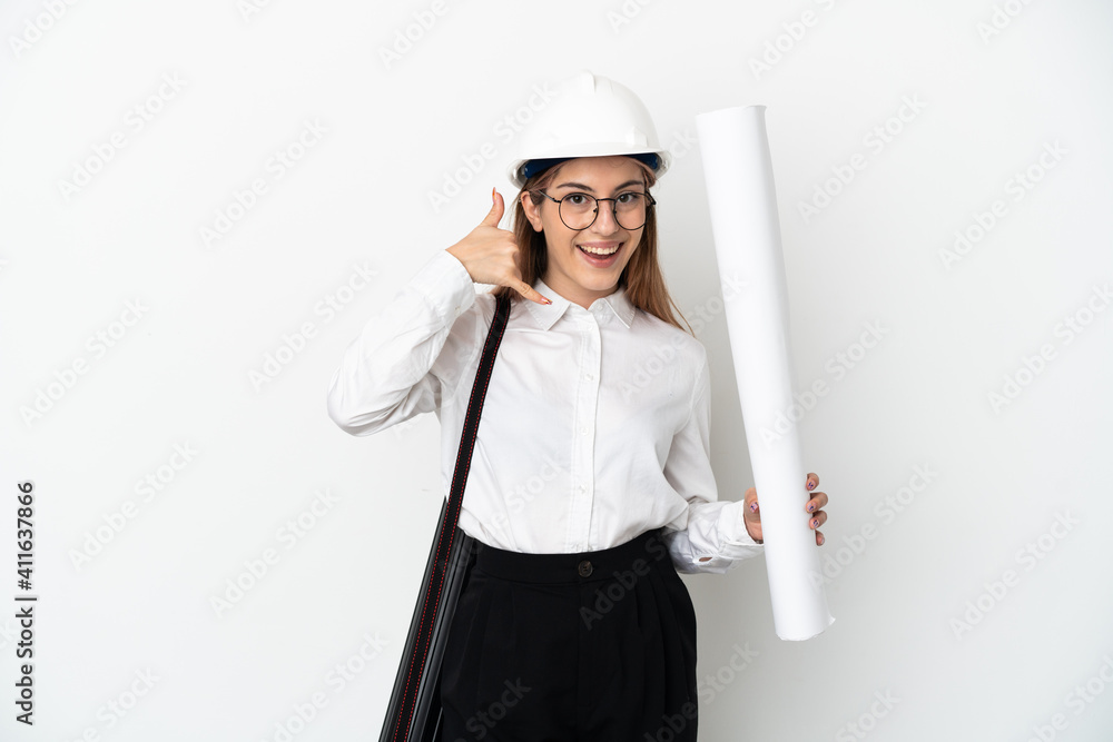 Young architect woman with helmet and holding blueprints isolated on white background making phone gesture. Call me back sign Young architect woman with helmet and holding blueprints isolated on white background making phone gesture. Call me back sign