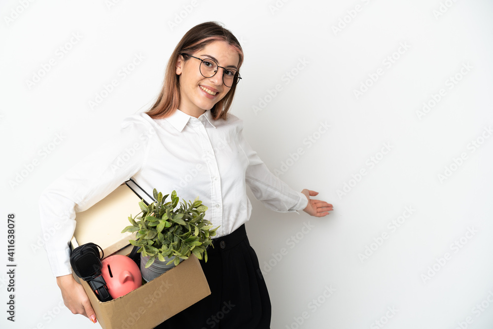 Young caucasian woman moving in new home among boxes isolated on white background extending hands to the side for inviting to come Young caucasian woman moving in new home among boxes isolated on white background extending hands to the side for inviting to come