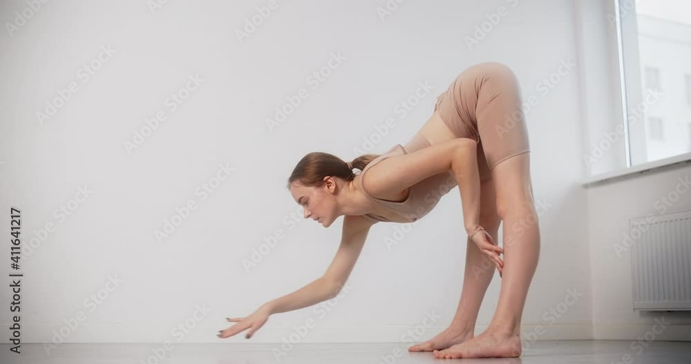 Yoga instructor performs stretching exercises in slow motion, gymnastic woman with tight body curves does pilates and yoga exercises on the white background, 4k 120p Prores HQ Yoga instructor performs stretching exercises in slow motion, gymnastic woman with tight body curves does pilates and yoga exercises on the white background, 4k 120p Prores HQ