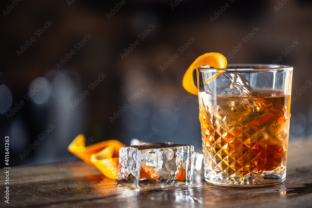 Old fashioned rum drink on ice with orange zest garnish - obrazy, fototapety, plakaty 