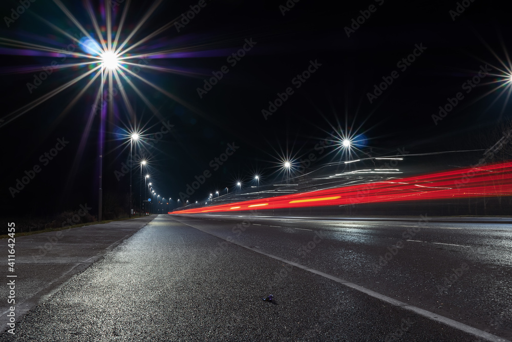 Car light trail and city light. Night shot. Vehicle back lights illumination on highway Car light trail and city light. Night shot. Vehicle back lights illumination on highway