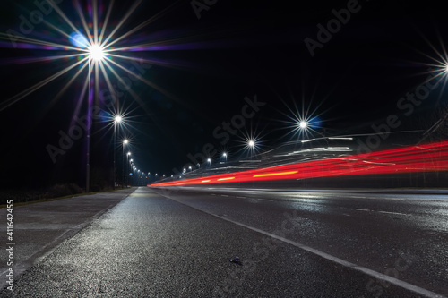 Car light trail and city light. Night shot. Vehicle back lights illumination on highway