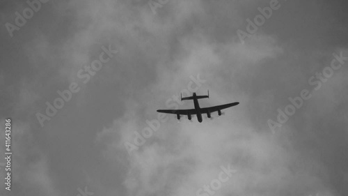 Avro Lancaster flies overhead. The Lancaster was a British bomber from World War 2. Black and white. photo