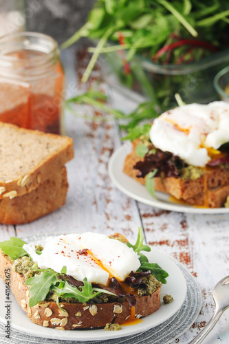 Homemade sandwiches with pesto, green salad and poached eggs