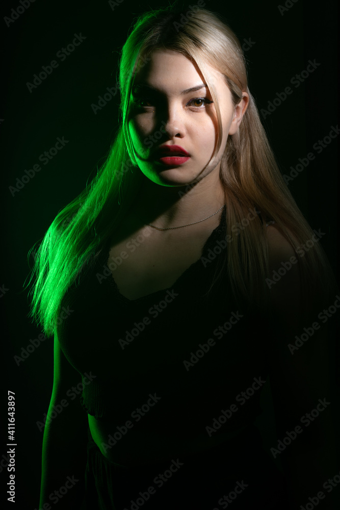 portrait of a blonde girl with bright makeup in green light portrait of a blonde girl with bright makeup in green light
