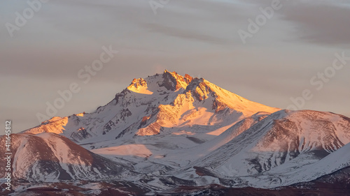 Volcanic Erciyes at sunset in Kayseri. Snowy scarlet mountain. Erciyes is a large stratovolcano, reaching a height of 3,864 m it the highest mountain and most voluminous volcano of Central Anatolia