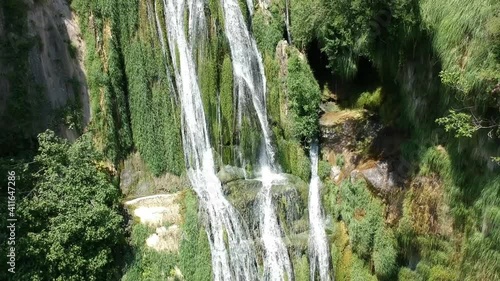 Aerial views of a waterfall with a cave and an old building in Catalonia, Spain