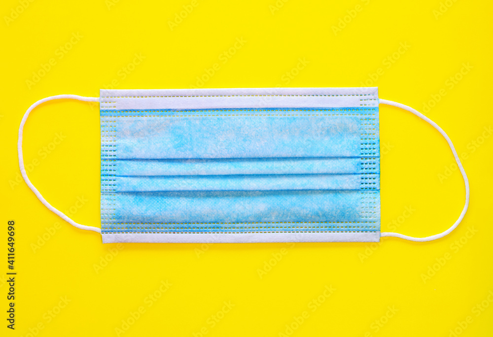 Blue medical mask on yellow background Blue medical mask on yellow background