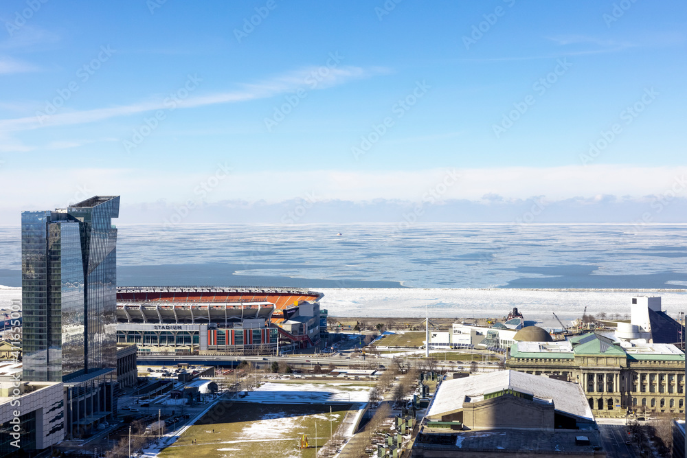 Panorama of the city of Cleveland with view over frozen Lake Erie, the football stadium, museums, hotels, bank towers and other landmark buildings. 
