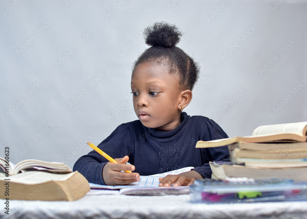African girl child studying with books on her table for excellence in her education African girl child studying with books on her table for excellence in her education