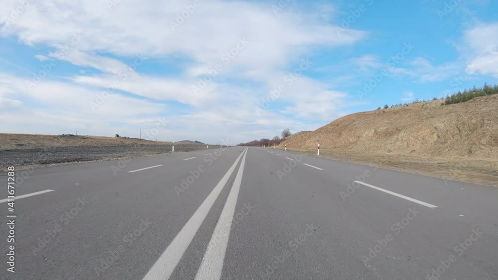 Long way road at the mountain with pines forest in front and blue clear sky Long way road at the mountain with pines forest in front and blue clear sky