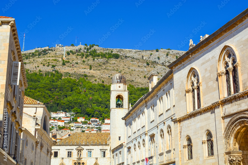 Old Town of Dubrovnik, Croatia on a sunny day with the City Bell Clock Tower and the Dubrovnik Cable Car and Mount Srd behind