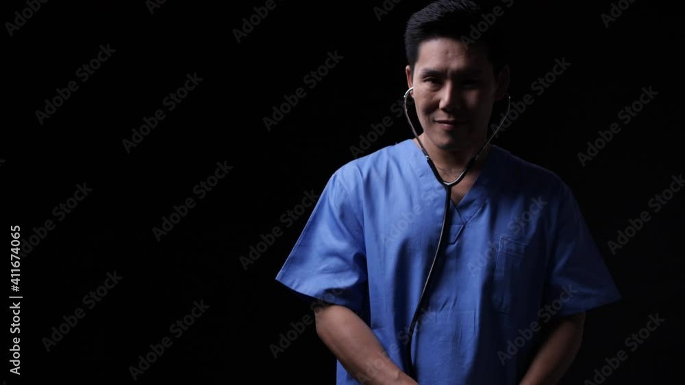 Portraits of Doctor smiling expression with black background. Asian man wearing medical dress appropriately. Doctor posing and looking at camera with presentation hospital uniform. Portraits of Doctor smiling expression with black background. Asian man wearing medical dress appropriately. Doctor posing and looking at camera with presentation hospital uniform.