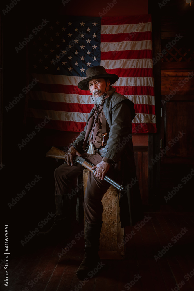Fototapeta premium Cowboy posing with rifle gun on hand to show protected weapon ,vintage style.