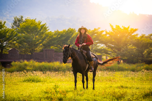 cowboys horseback riding at sunset time with sunlight ray sky background © APchanel