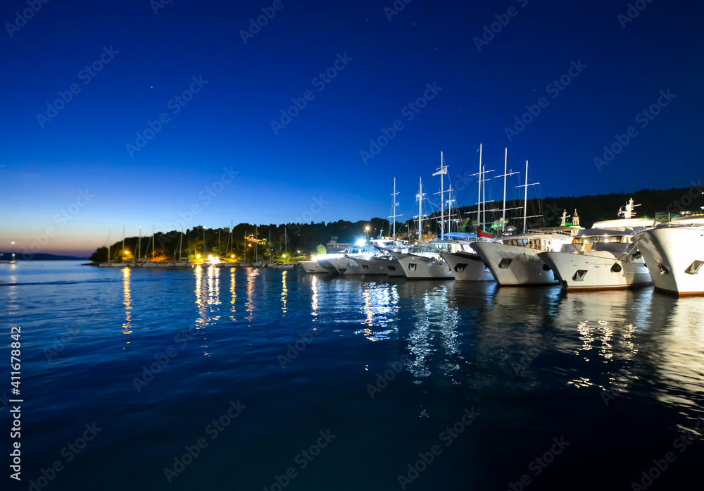 Sailboats, and yachts line up in the evening at the port harbor of the Dalmatian Coast island of Hvar, Croatia.