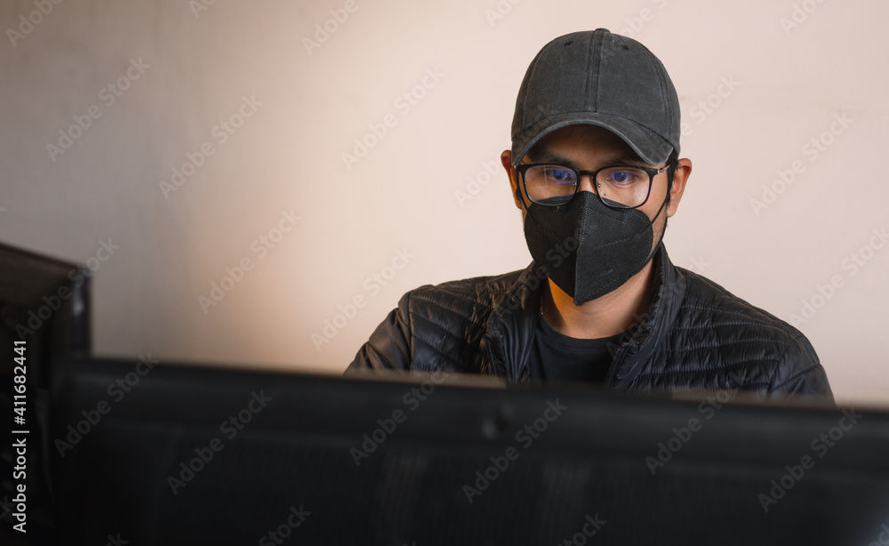 young man working with computer from his quarantined office young man working with computer from his quarantined office