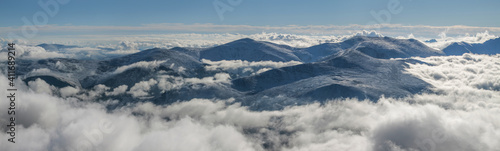 In the mountains above the clouds. Snow-covered slopes and peaks. © Valerii