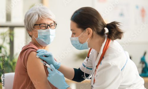 Doctor vaccinating a senior woman