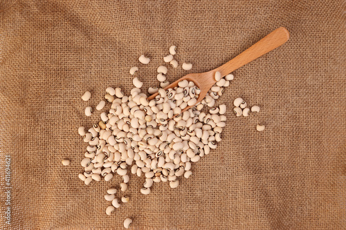 Blackeye beans in wooden scoop spoon jute yarn fabric background photo