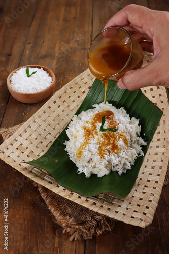 Ketan kelapa parut, one of Javanese traditional snack, made from glutinous rice (sticky rice) cooked with coconut milk, serve with grated coconut on top and coconut milk jam photo