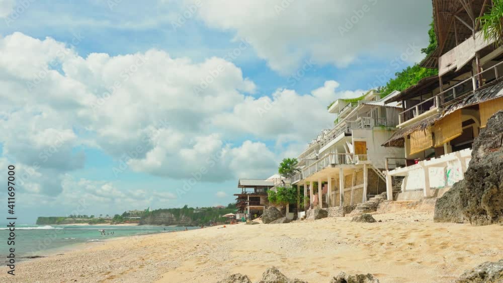 Bingin Beach Bali, is amazing sand beach with scenery mountain cliff in sea on background traditional bamboo hotels. Pantai Bingin surfer paradise for active lifestyle travel tourist. 4K Bingin Beach Bali, is amazing sand beach with scenery mountain cliff in sea on background traditional bamboo hotels. Pantai Bingin surfer paradise for active lifestyle travel tourist. 4K