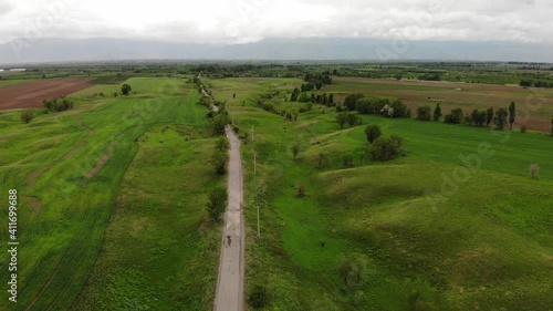 Aerial video of green hills and road. Beautiful countryside. Great advertisement for nature. Spring day.