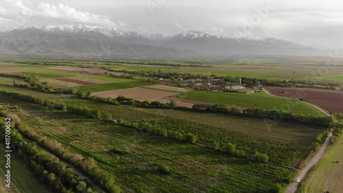 Aerial panorama of green fields in spring. View of the mountain peaks. Excellent landscapes for advertising. Kazakhstan.