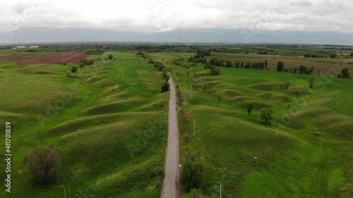 Beautiful green hills. Countryside. Road to the field. Aerial video. Spring advertisement for a film about nature. Kazakhstan. Very green landscape.