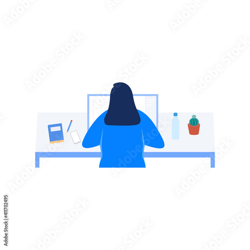 Woman sits facing the computer screen and her back to the camera