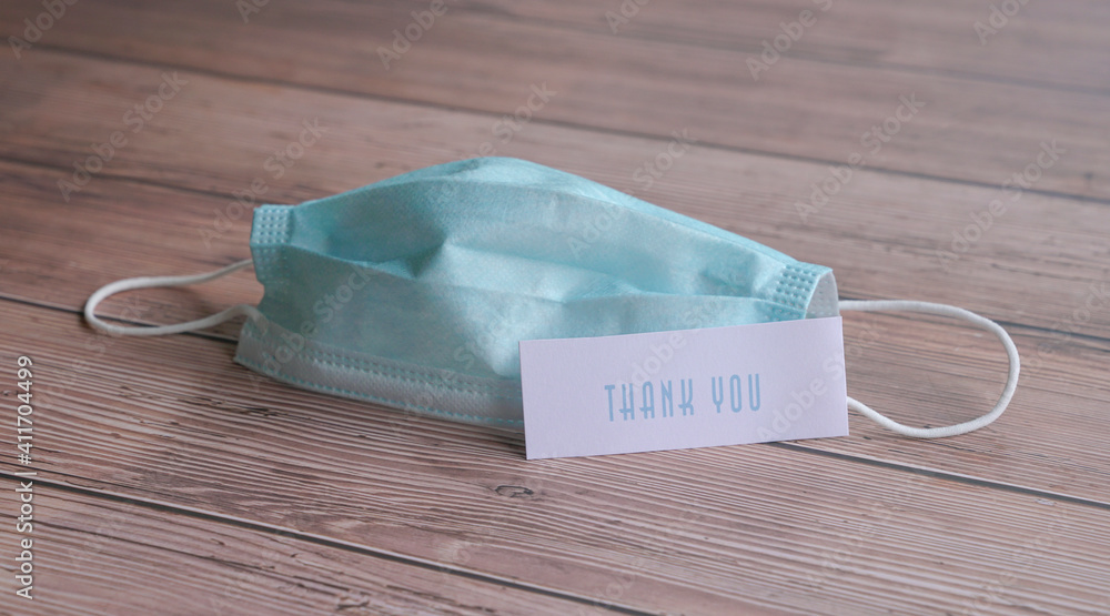 Thank you note next to medical face mask. Stock Photo | Adobe Stock