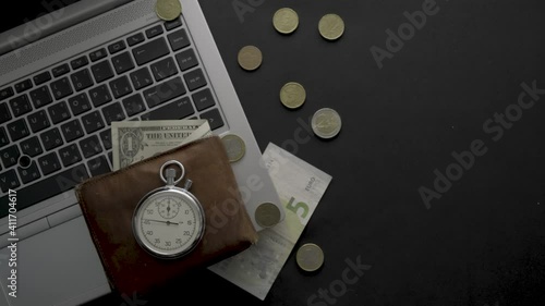 laptop  wallet  stopwatch  and money on a black background