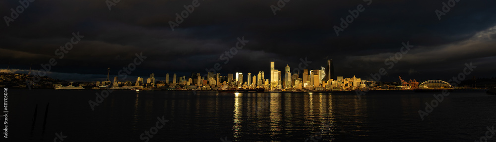Panaramic view of Seattle citycape with dramatic light as seen from Alki Beach in West Seattle over the water of the Puget Sound