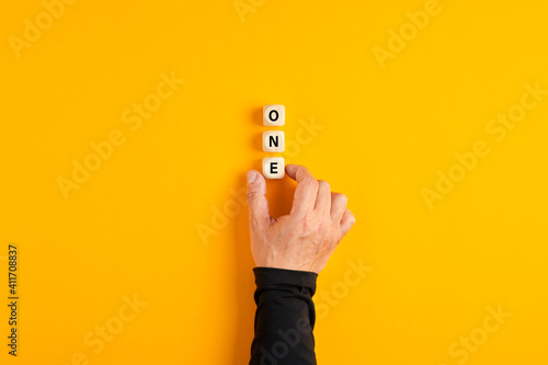 Male hand placing the wooden blocks with the number one written