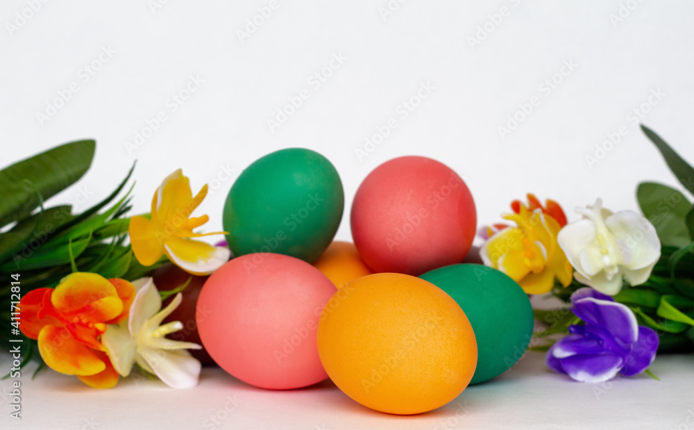 a heap of bright multicolored Easter eggs among flowers isolated on white background, copy space a heap of bright multicolored Easter eggs among flowers isolated on white background, copy space