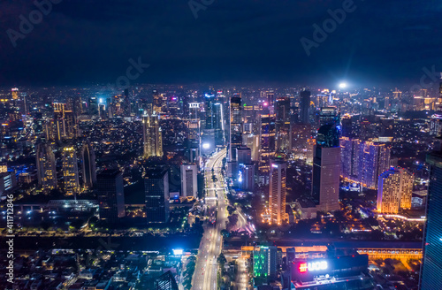 Aerial night cityscape of skyscrapers and multi lane highway traffic in modern city center of Jakarta, Indonesia Urban city center with high rise buildings at night