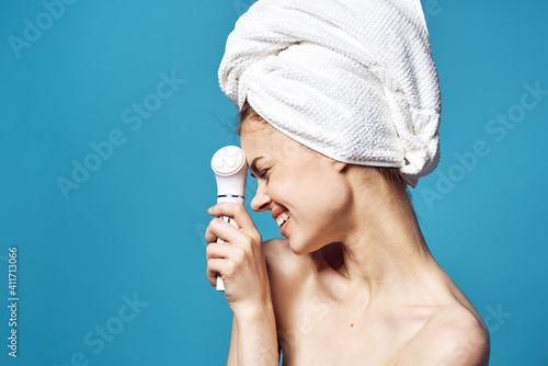 woman with bare shoulders with towel on head massager skin care