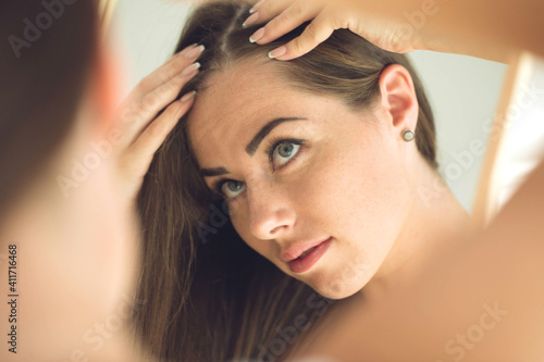 Close up portrait of frustrated young woman with spoiled hair on white background. High quality photo.