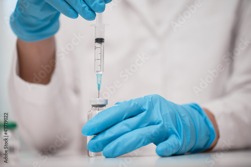 Doctor dials the vaccine into a syringe
