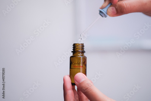 Concept image of Covid-19 Vaccine preparation by human hand over blurred bright background