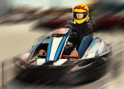 Happy cheerful smiling female go-cart racer at kart circuit outdoors