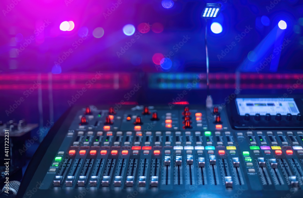Production Concept At the concert, a mixer for mixing music has lots of buttons with a blurred background in pink and blue tones. Production Concept At the concert, a mixer for mixing music has lots of buttons with a blurred background in pink and blue tones.