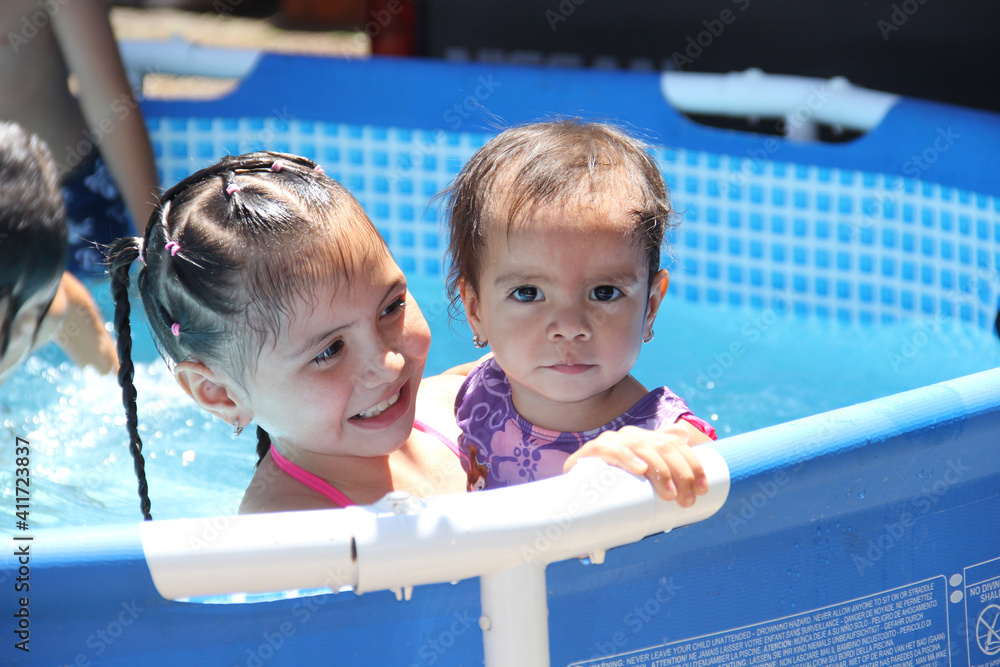 Niñas en alberca piscina portátil verano primavera semana santa en casa  nadando mexicanas latinas latinoamérica Stock Photo | Adobe Stock