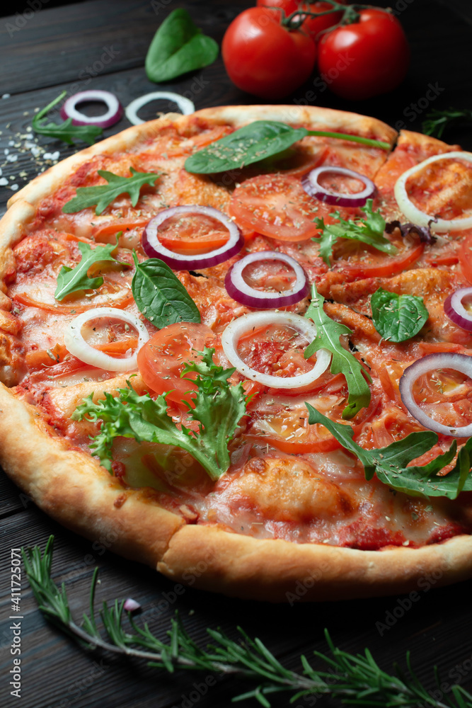 Delicious classic Italian pizza with tomatoes on a dark wooden background